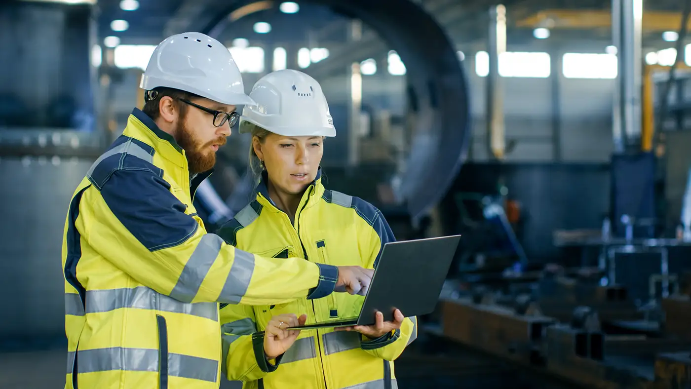 two power plant experts wearing safety helmets and yellow jackets